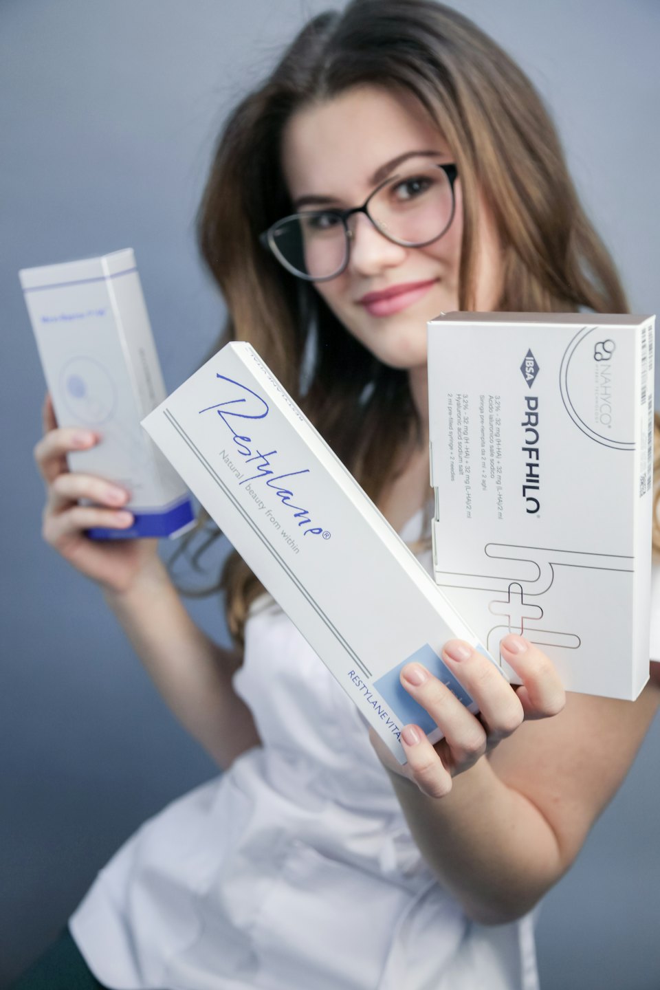 Medisch professional met dozen Restylane en Profhilo in handen.